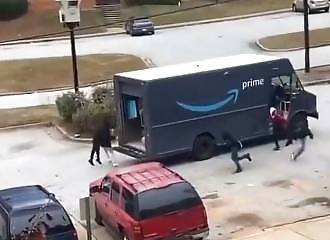 A group of riffraff empty an Amazon delivery truck in front of a helpless delivery girl