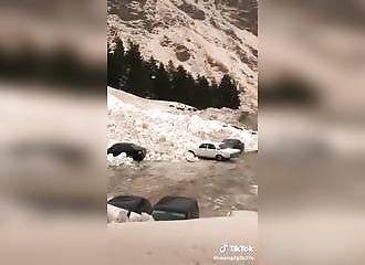 Des voitures sur un parking se font ensevelir sous la neige
