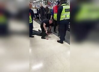 A man fights with a security guard in a store, a customer arrives to calm him down