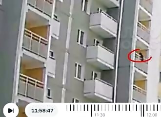 A man saves a child hanging from a balcony