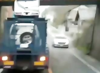 Un camion transporteur de voitures tente de passer sous un pont très bas