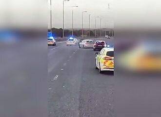  Police officers ram a BMW against the flow of traffic on the freeway to stop it 