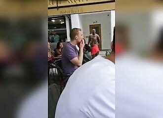 Un homme nu crie sur les clients d'un restaurant