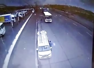 Stopped at the side of the road, a bus runs into them