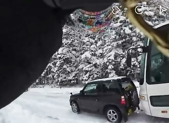 Shock: a motorist is pushed by a bus that slides helplessly on the snow