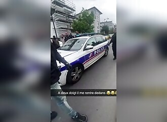 A man stands in the middle of the road to stop a police car